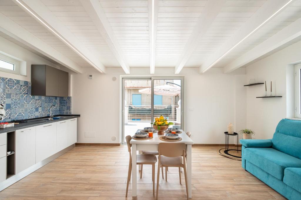 a kitchen and living room with a table and a blue couch at Da Felicia in Capo dʼOrlando