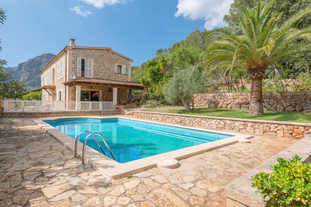 una villa con piscina frente a una casa en Hall of The Mountain Pool - Bunyola, en Bunyola