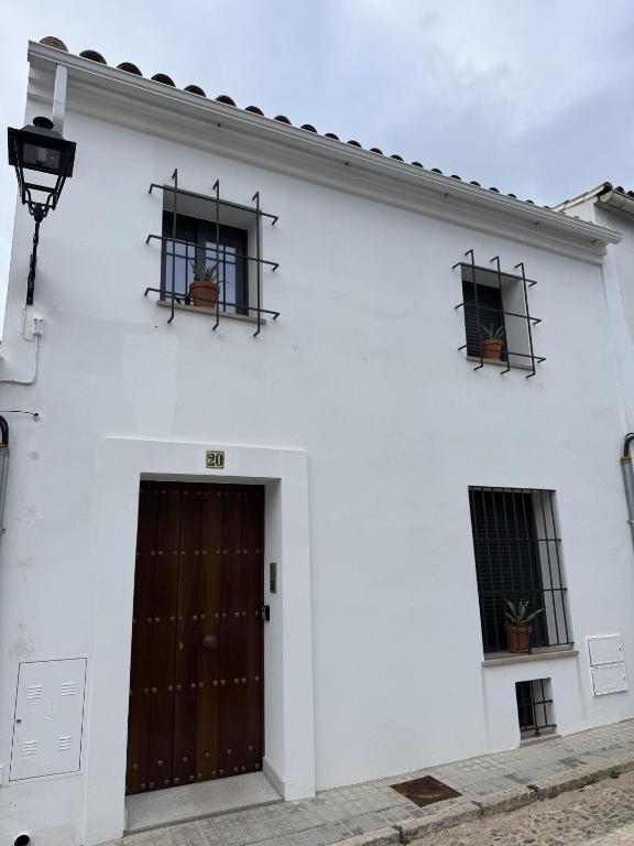 a white building with two windows and a door at Apartamentos La Gruta de Aracena 3 in Aracena