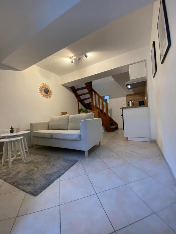 un salon avec un canapé et une table dans l'établissement Petite maison indépendante à 7mn de la plage, à Douvres-la-Délivrande