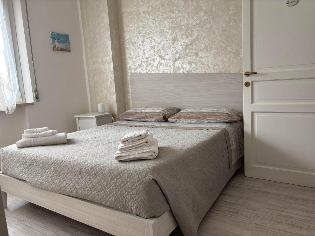 una camera da letto con un letto con asciugamani sopra di Appartamento Aria di Mare a San Benedetto del Tronto