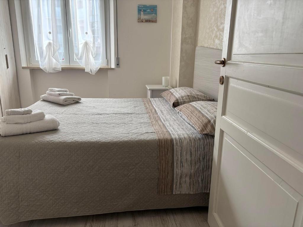 una camera da letto con un letto con due asciugamani sopra di Appartamento Aria di Mare a San Benedetto del Tronto