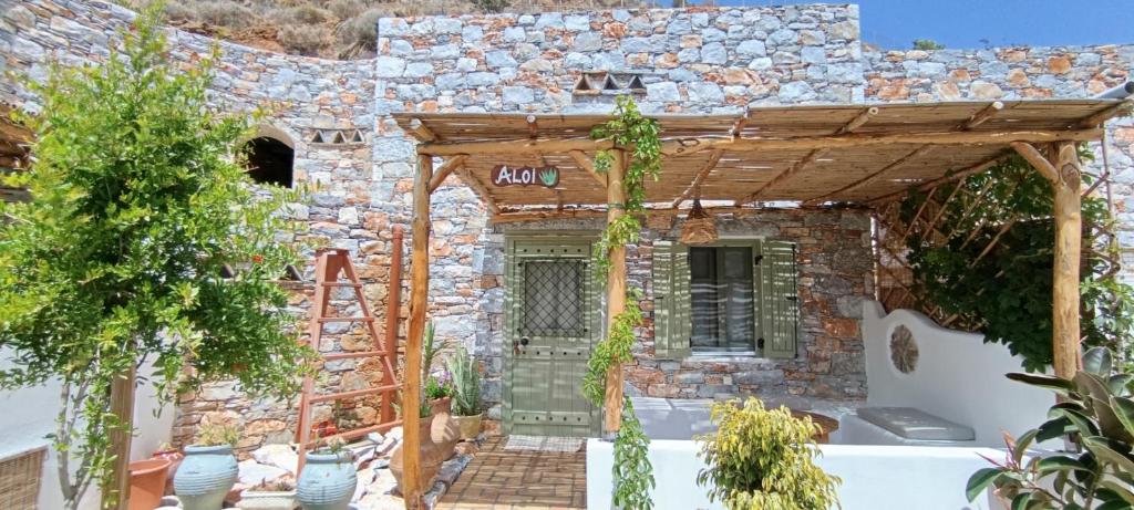 a stone house with a porch and a stone wall at Aliori art caves in Aegiali