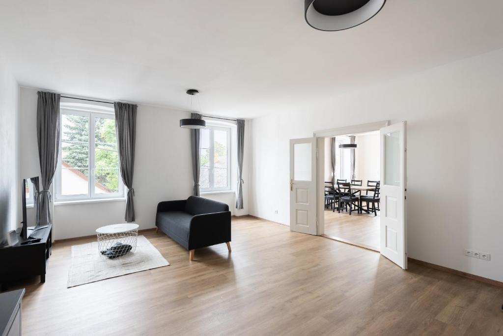 a living room with a black chair and a mirror at Vacov Apartment in Vacov