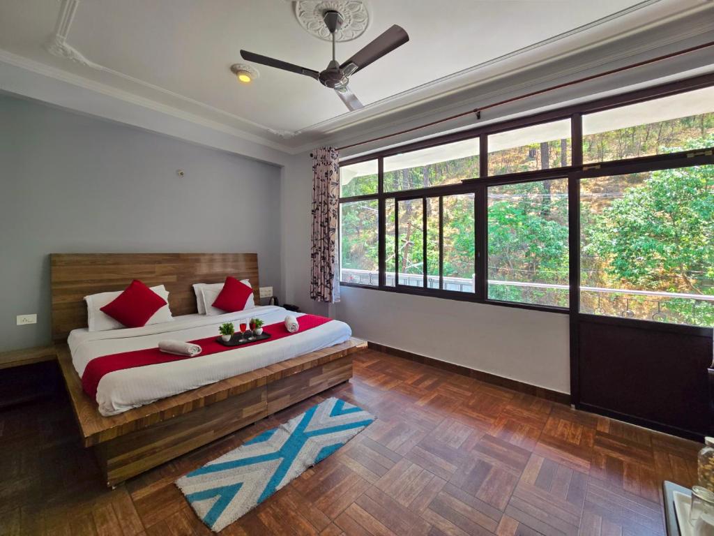 a bedroom with a large bed and large windows at Hotel City Gold in Dharmsāla