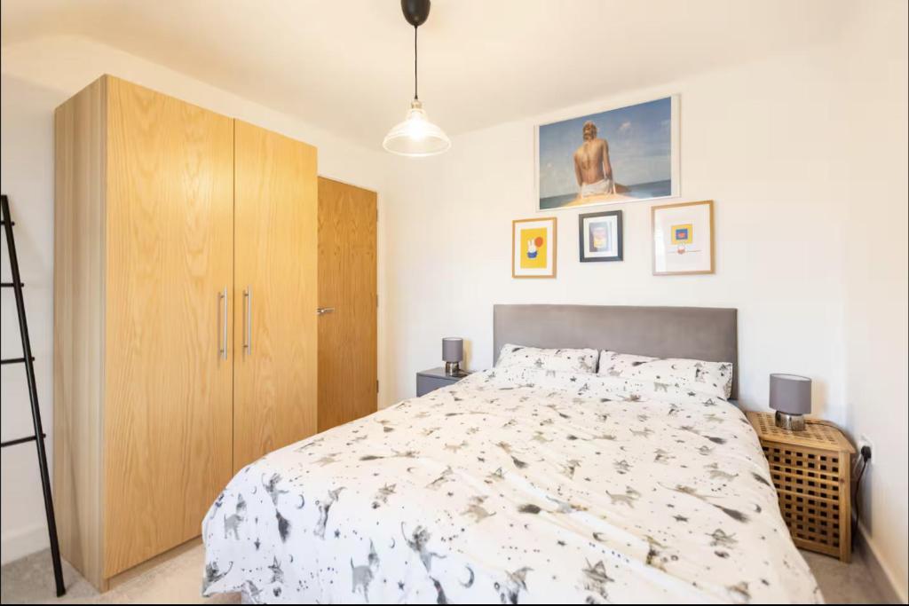 a bedroom with a bed and a wooden cabinet at Very Comfortable Rooms and Welcoming live in Hosts in Killingbeck
