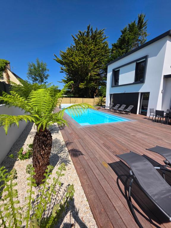 a villa with a swimming pool and a wooden deck at Villa Babalélé, Fouesnant in Fouesnant