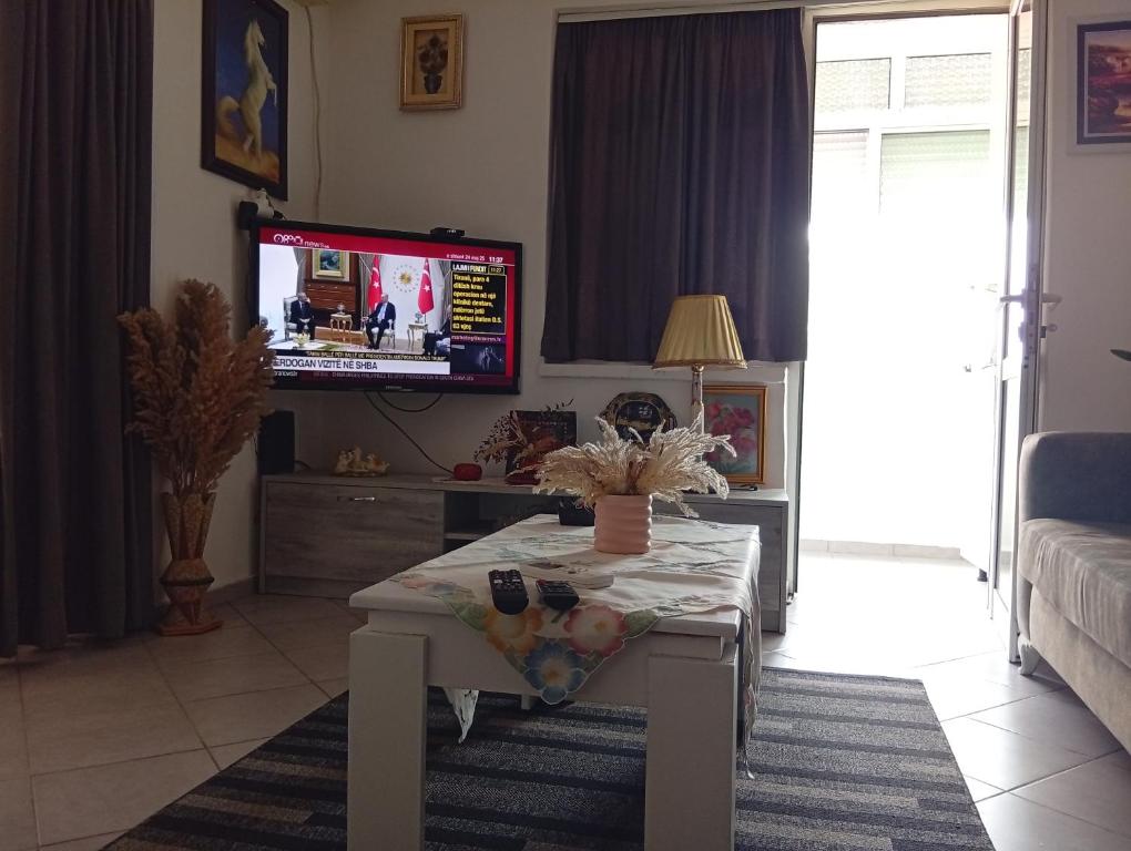 Una sala de estar con una mesa y un televisor. en Your Own Privacy, en Tirana