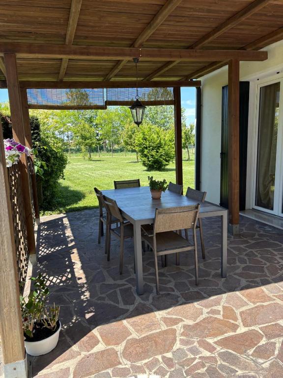 a patio with a table and chairs under a pergola at La Brentella in Arzergrande