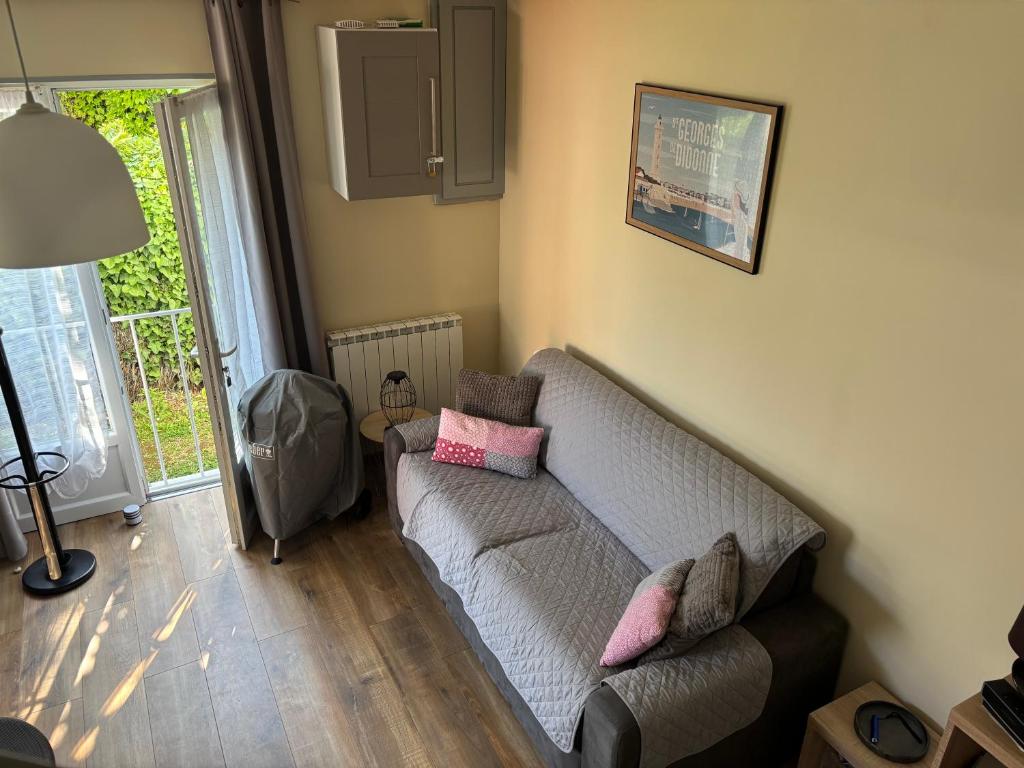 un salon avec un canapé et une lampe dans l'établissement Maisonnette au pied du marché et 300 m de la plage, à Saint-Georges-de-Didonne