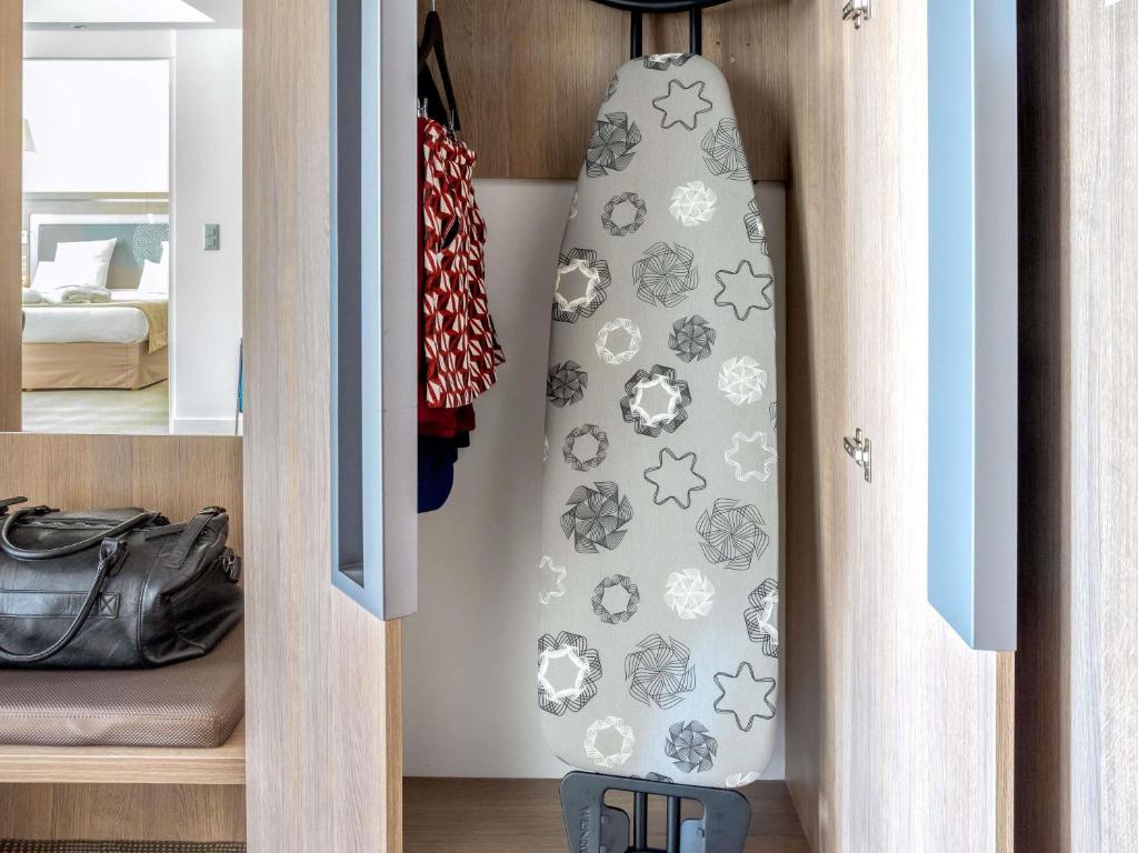 a tie with soccer balls and stars is hanging in a closet at Novotel Lugano Paradiso in Lugano