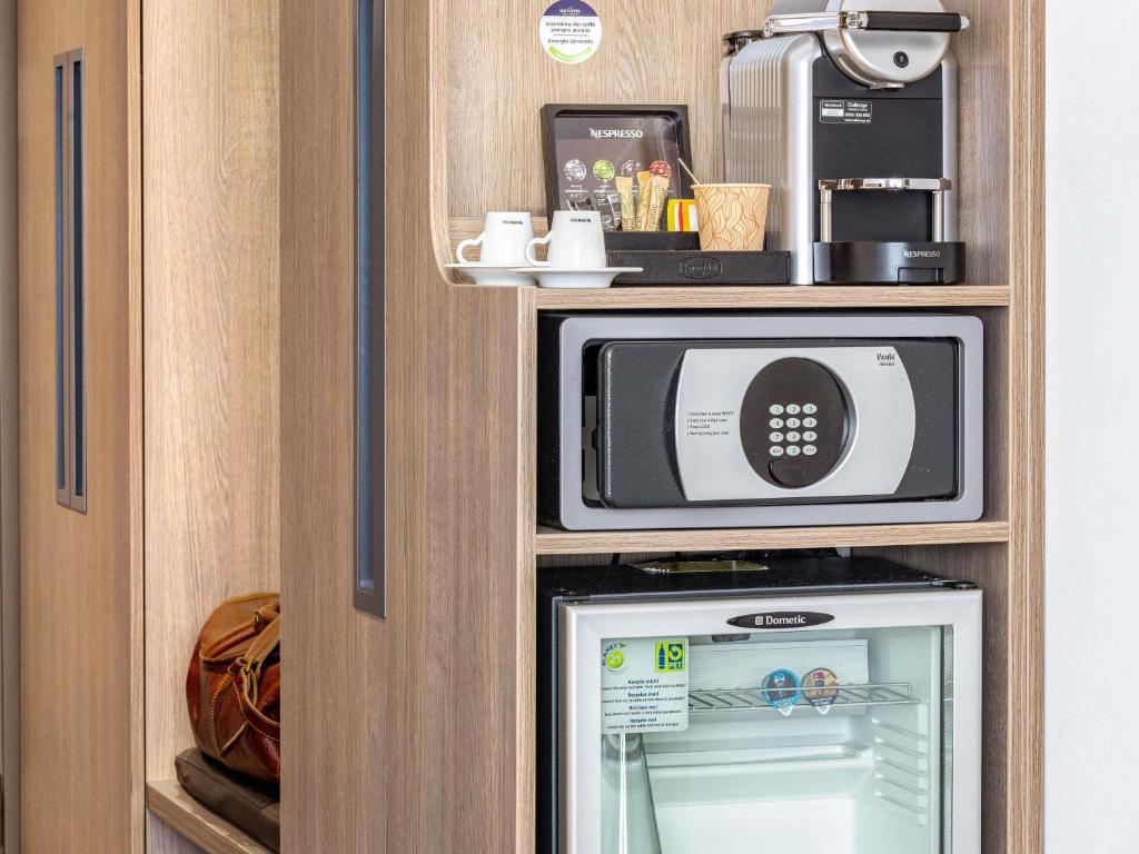 a microwave and a refrigerator in a cabinet at Novotel Lugano Paradiso in Lugano