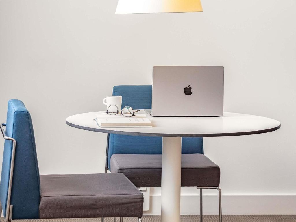 a table with a laptop computer on top of it at Novotel Lugano Paradiso in Lugano