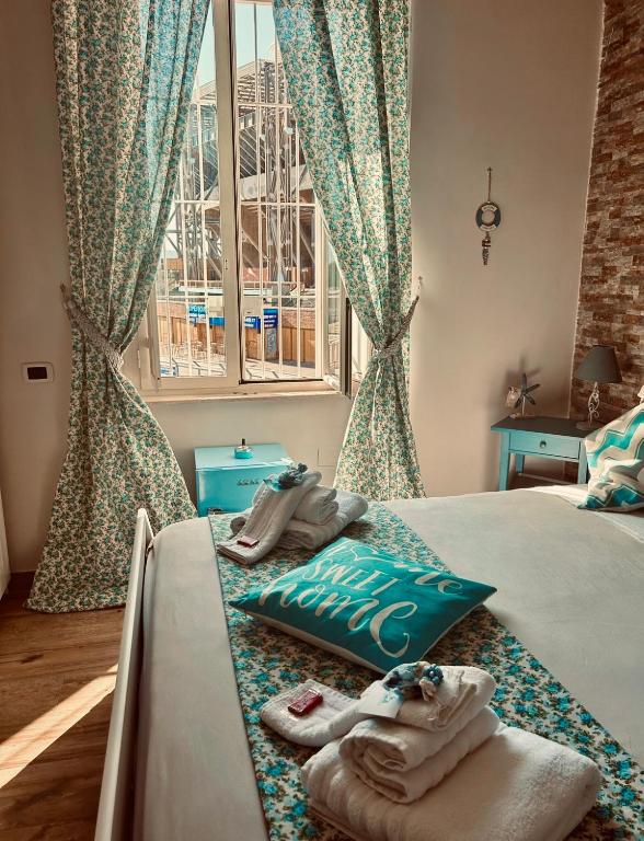 una camera da letto con asciugamani su un letto con finestra di Le Stanze di Megaride a Napoli