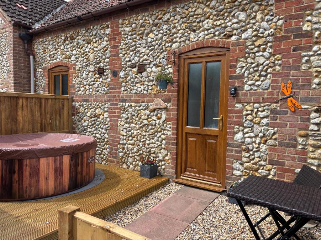 a brick house with a wooden door and a wooden deck at The Ducks - Stunning remote Norfolk Appt with Lazy Spa in Mileham