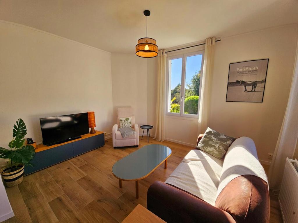 un salon avec un canapé et une télévision dans l'établissement Pause détente dans Le Vieux Deauville, à Deauville