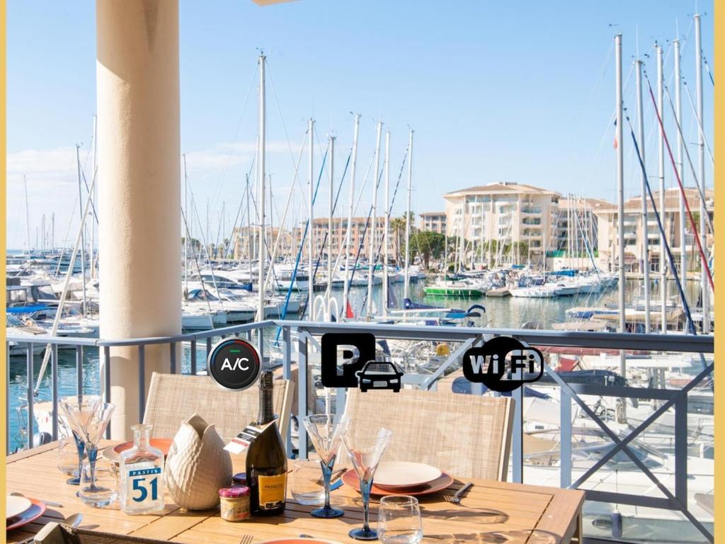 - une table sur un balcon avec un port de plaisance avec des bateaux dans l'établissement Sur le port, 3 cham, parking, à Fréjus