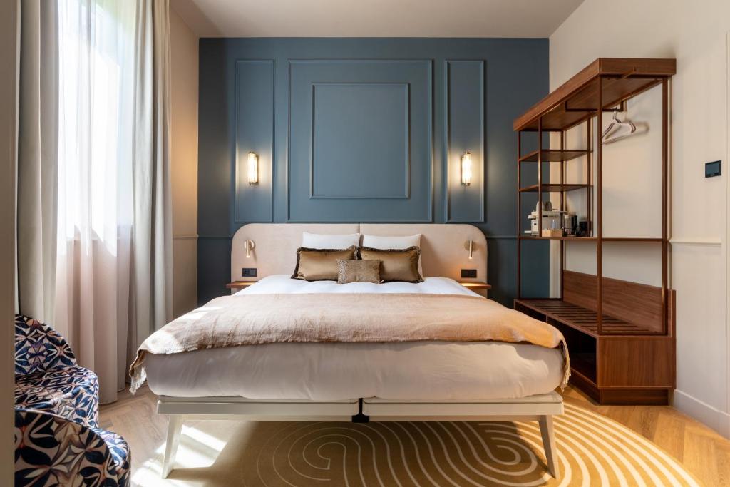 Un dormitorio con una cama grande y una pared azul. en Boutique Hotel Malie House, en Utrecht