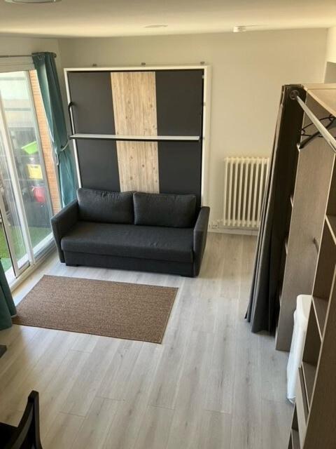 - un canapé noir dans le salon dans l'établissement Charmant studio Avignon intra-muros, à Avignon