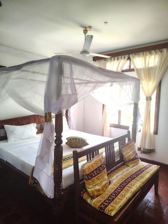 Postel nebo postele na pokoji v ubytování Gecko Hotel Diani