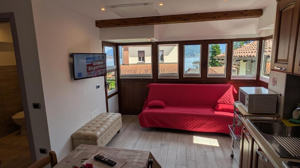 a living room with a red couch and a tv at Casa Nicolò Vista Lago in Stresa