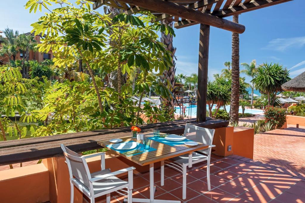 a table and chairs on a patio with a view of the ocean at Royal Hideaway Sancti Petri in Chiclana de la Frontera
