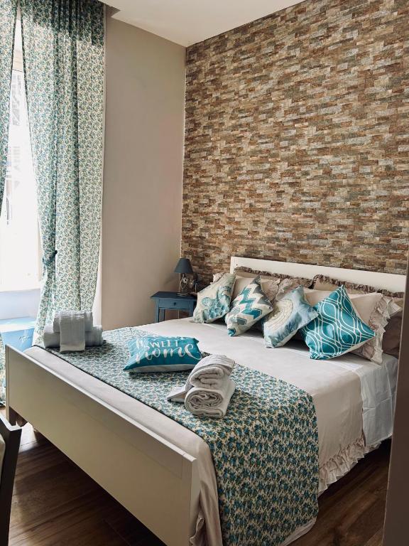 una camera da letto con un letto con cuscini blu e un muro di mattoni di Le Stanze di Megaride a Napoli