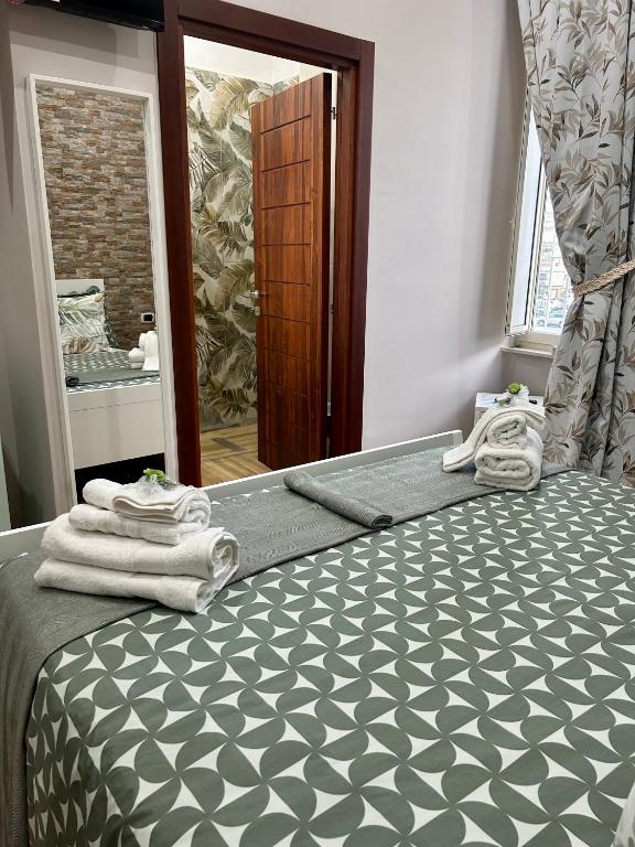 una camera da letto con un letto con asciugamani sopra di Le Stanze di Megaride a Napoli