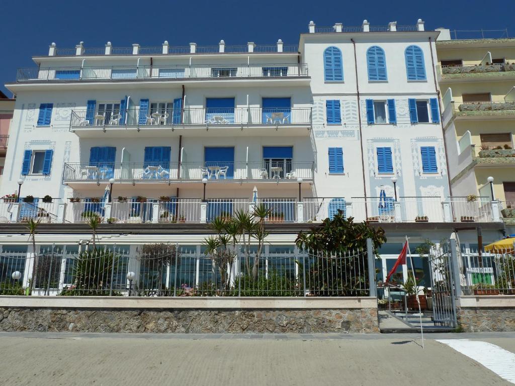 un gran edificio blanco con una valla delante en La Balnearia, en Alassio
