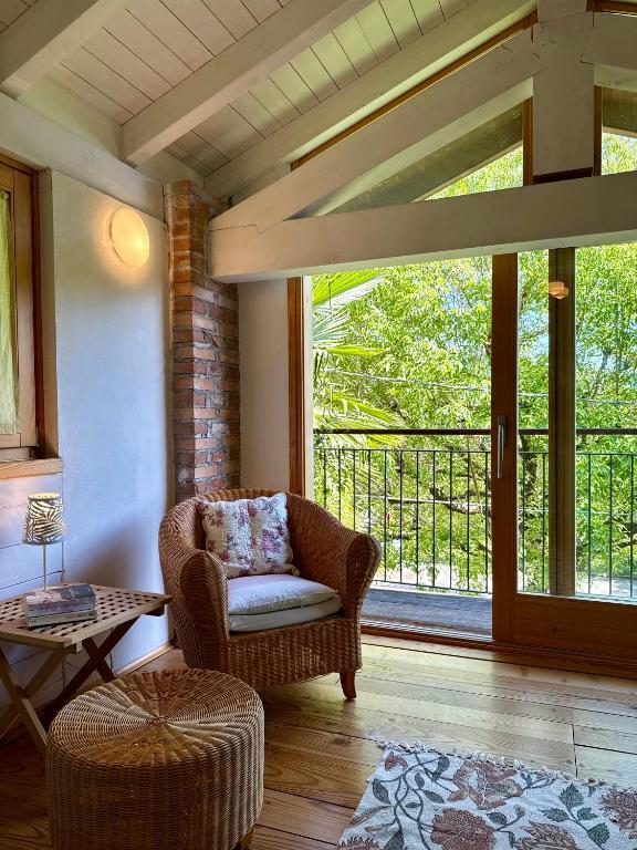 a living room with a chair and a large window at Magic Garden - Since 1911 in Luino