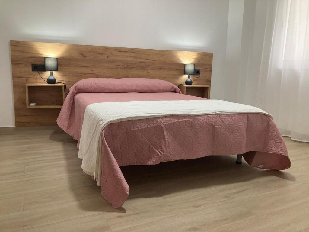 ein Schlafzimmer mit einem großen Bett mit einem hölzernen Kopfteil in der Unterkunft El Rincón de Elena II in Cazorla