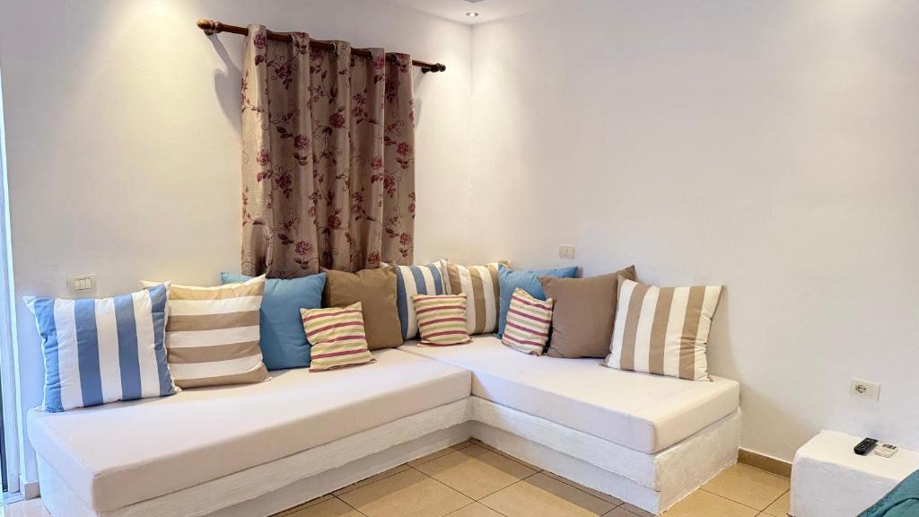 a white couch with many pillows on it at Rida Village Ksamil Island in Ksamil
