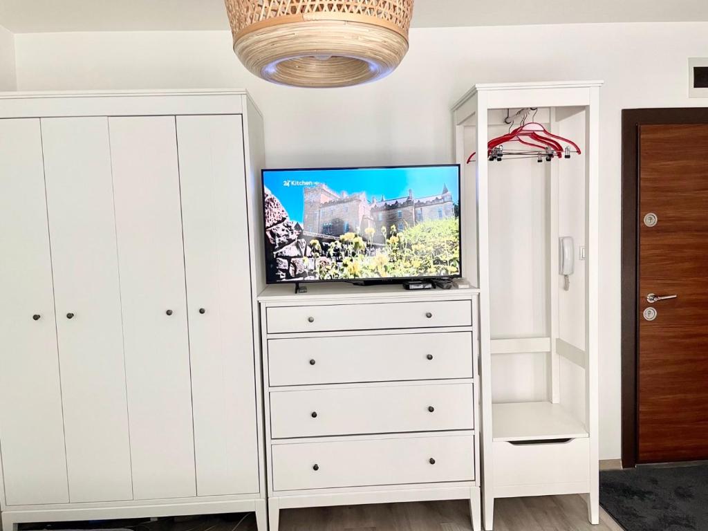 een witte dressoir met een tv erop bij Deluxe studio beach Lazur in Boergas