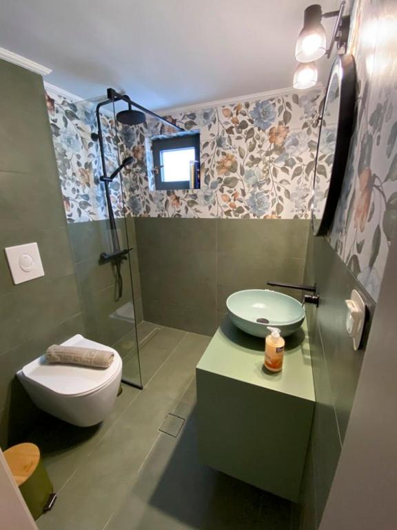 łazienka z toaletą, umywalką i prysznicem w obiekcie panos luxury apartment w Heraklionie