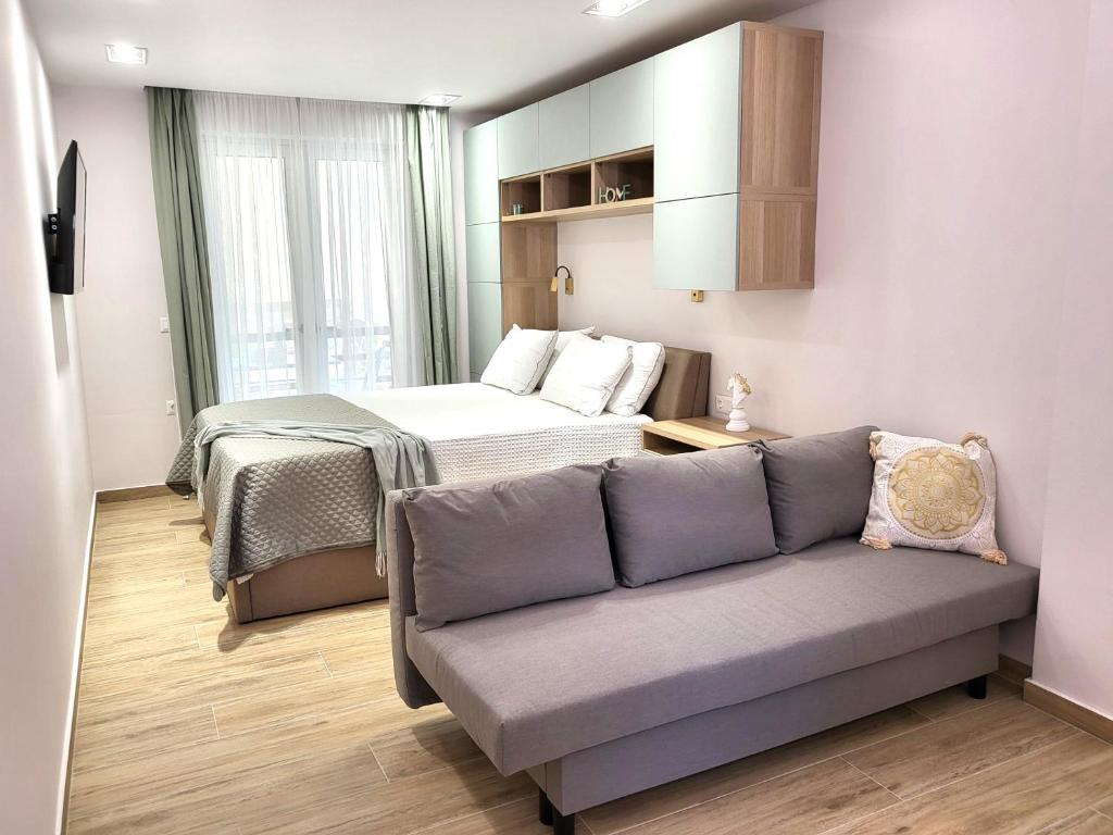 un salon avec un canapé et un lit dans l'établissement Meltemi Retreat, à Tolón