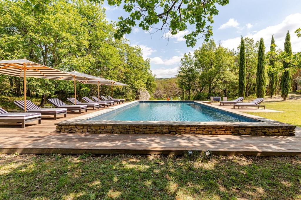 una piscina con sillas y sombrillas alrededor en Villa Bim, en Bonnieux