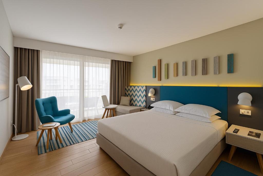 スースにあるSousse Pearl Marriott Resort & Spaのベッドルーム(大型ベッド1台、青い椅子付)