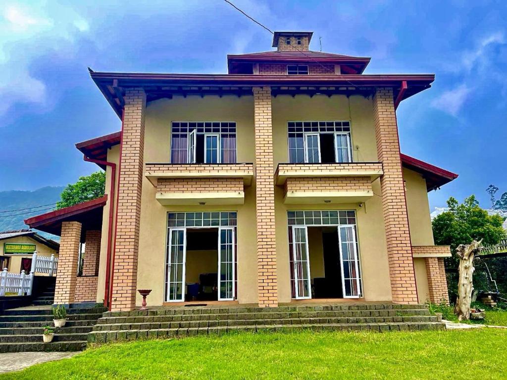 a large brick house with a tower at The Vatican in Nuwara Eliya