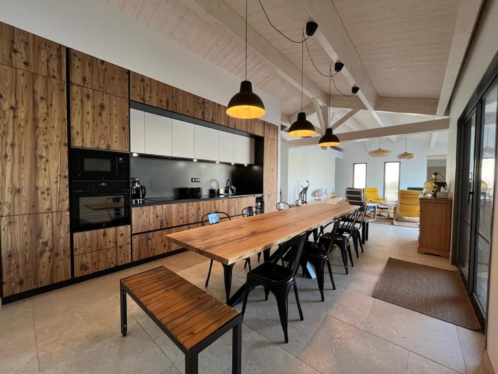 une grande salle à manger avec une grande table et des chaises en bois dans l'établissement Villa d'Oléron 5 étoiles avec piscine, à Dolus-d'Oléron