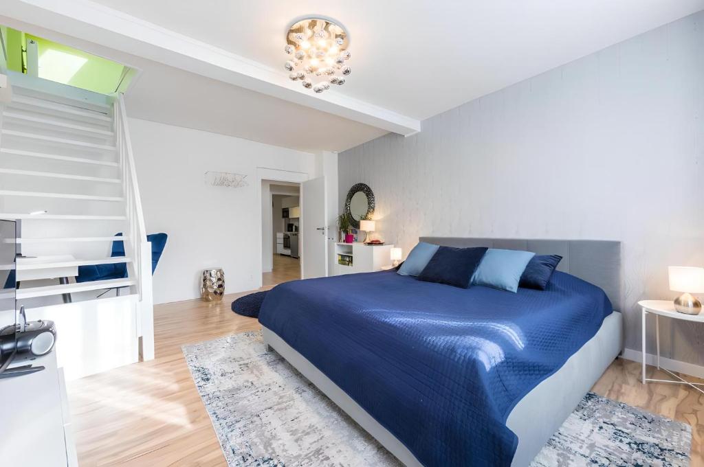 Un dormitorio con una cama azul y una lámpara de araña. en Promenade View Apartment, en Karlovy Vary