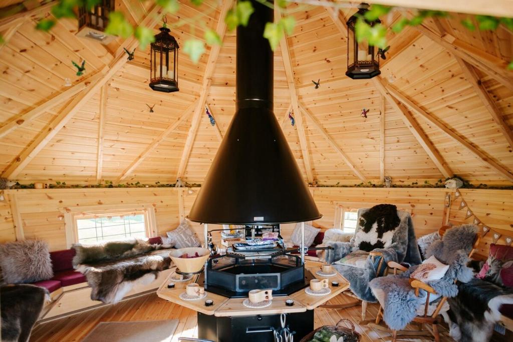 a living room with a stove in a log cabin at Nirvana Glamping in Tiverton