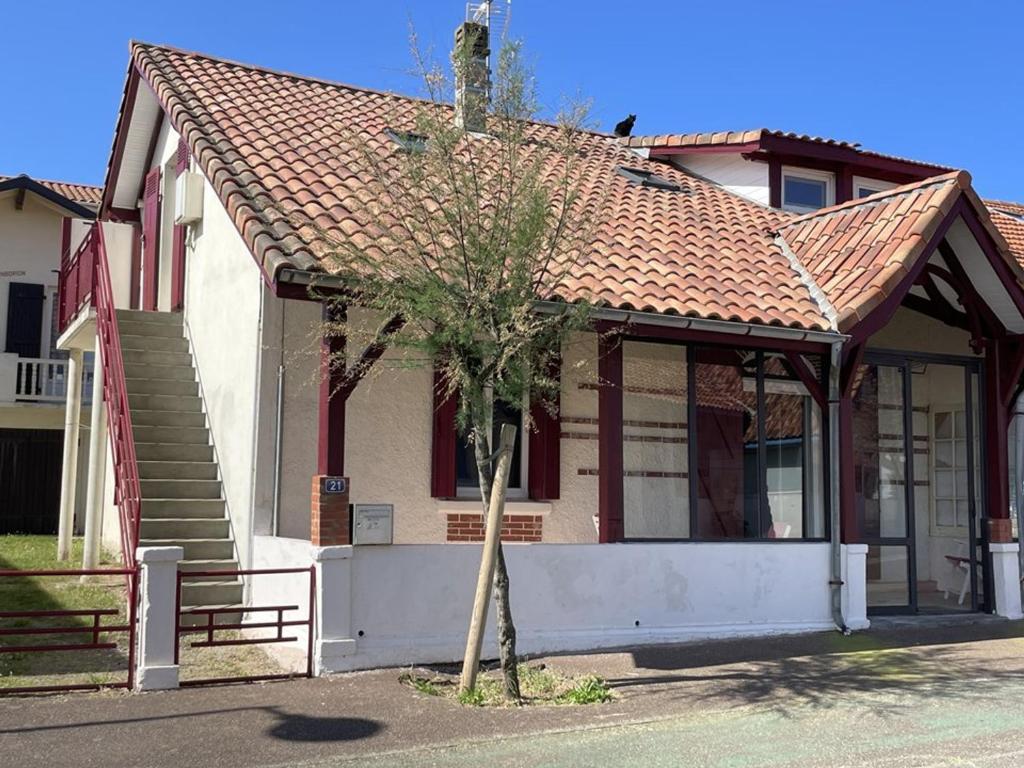 une maison avec un arbre devant dans l'établissement T4 confortable 6 pers avec Wifi, terrasse et jardin à 200m de la plage - Vieux-Boucau-les-Bains - FR-1-379-158, à Vieux-Boucau-les-Bains