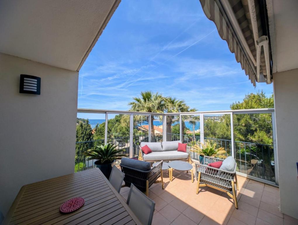 un patio avec une table et des chaises sur un balcon dans l'établissement vue mer grande terrasse plage à 2 min à pieds, à Sanary-sur-Mer