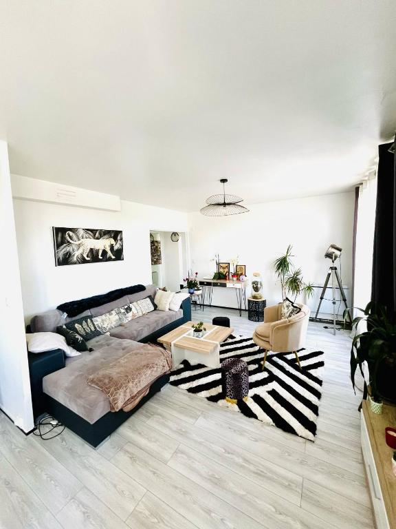 un salon avec un canapé et une table dans l'établissement Appartement proche centre-ville, à Bergerac