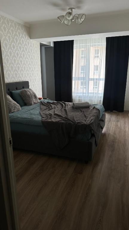 ein Bett in einem Schlafzimmer mit Holzboden in der Unterkunft Twice Rent in Chişinău