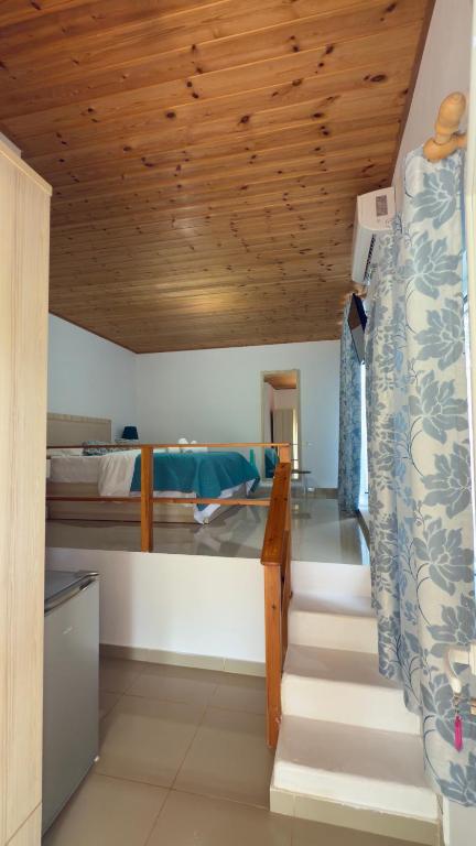 a bedroom with a bunk bed and a wooden ceiling at Rida Village Ksamil Island in Ksamil