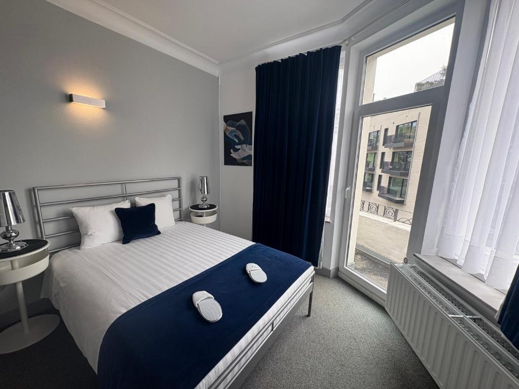 a bedroom with a large bed and a large window at Eurotel in Liège