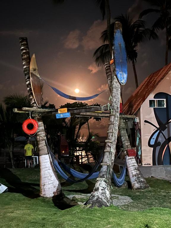 un resort con un'amaca sulla spiaggia di notte di Vila dos Gnomos Paraíso Místico Pé na Areia a Ilhéus