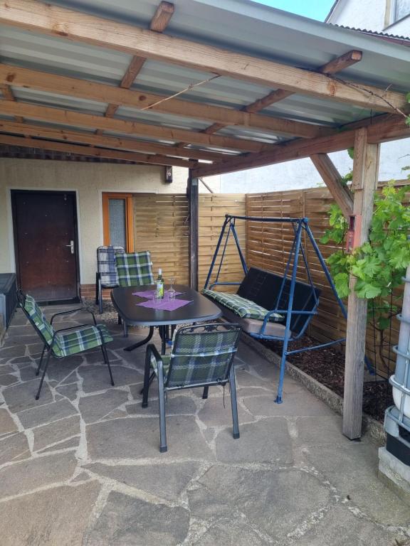a patio with a table and chairs under a pergola at Ferienwohnung Tom in Schnaittenbach