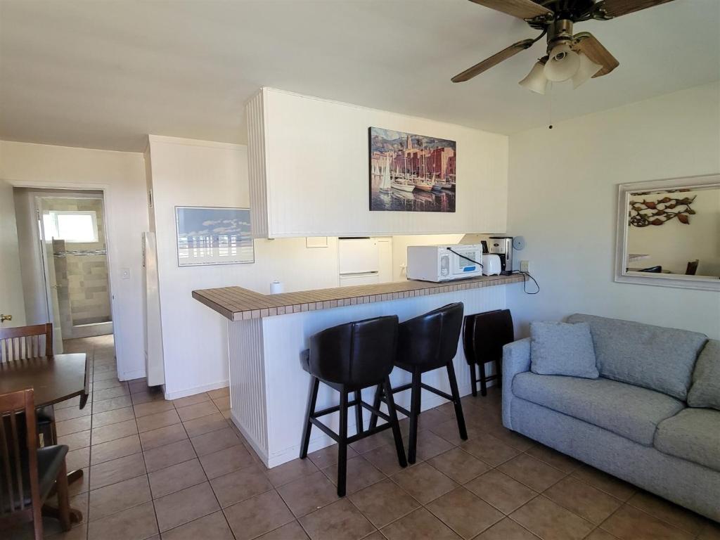 a living room with a couch and a kitchen with a counter at 1 Bed Beach Bungalow #130 in Carpinteria
